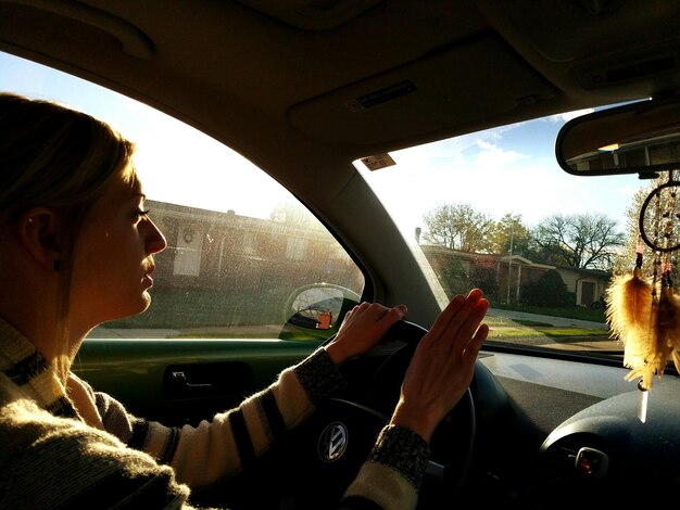 Foto mulher jovem a conduzir um carro.