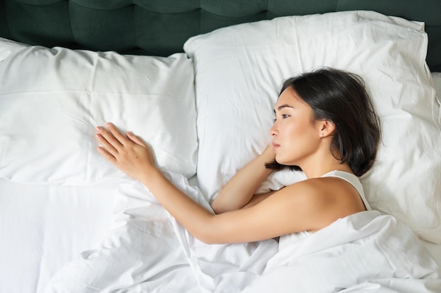 Foto mulher jovem a dormir na cama em casa.