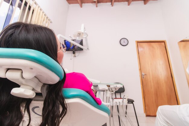 Foto mulher jovem à espera de ser vista pelo dentista no consultório dentário