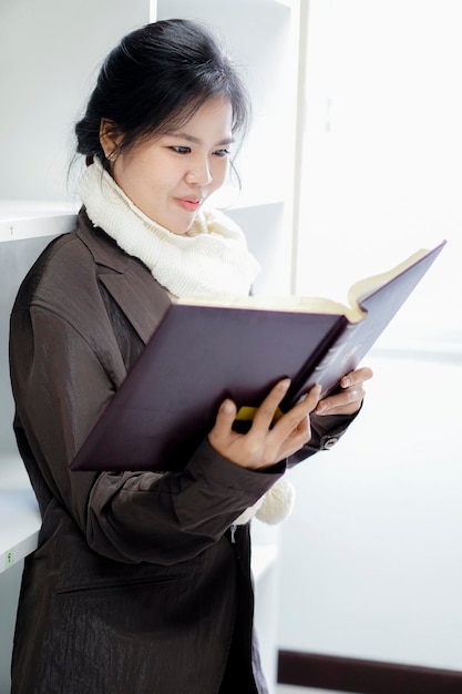 Mulher jovem a ler um livro na biblioteca