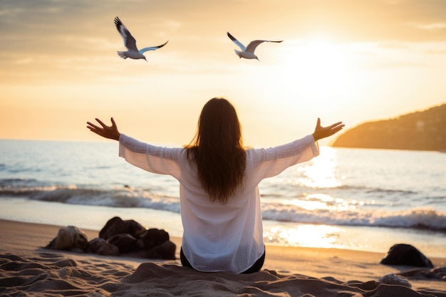 Mulher jovem a meditar na praia e gaivotas a voar