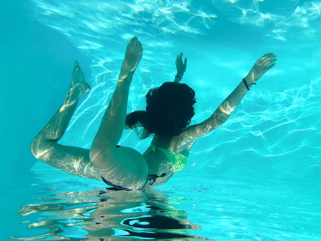 Foto mulher jovem a nadar na piscina.