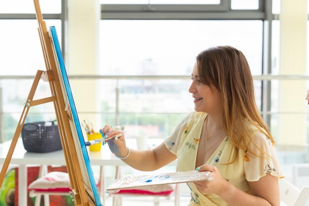 Foto mulher jovem a pintar em casa.