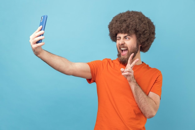 Foto mulher jovem a usar telemóvel contra um fundo azul