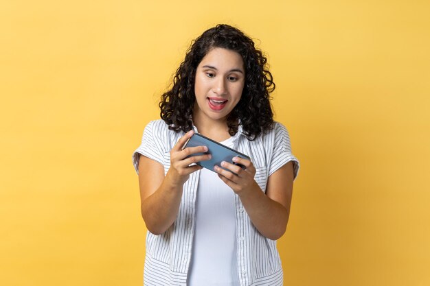 Foto mulher jovem a usar telemóvel.