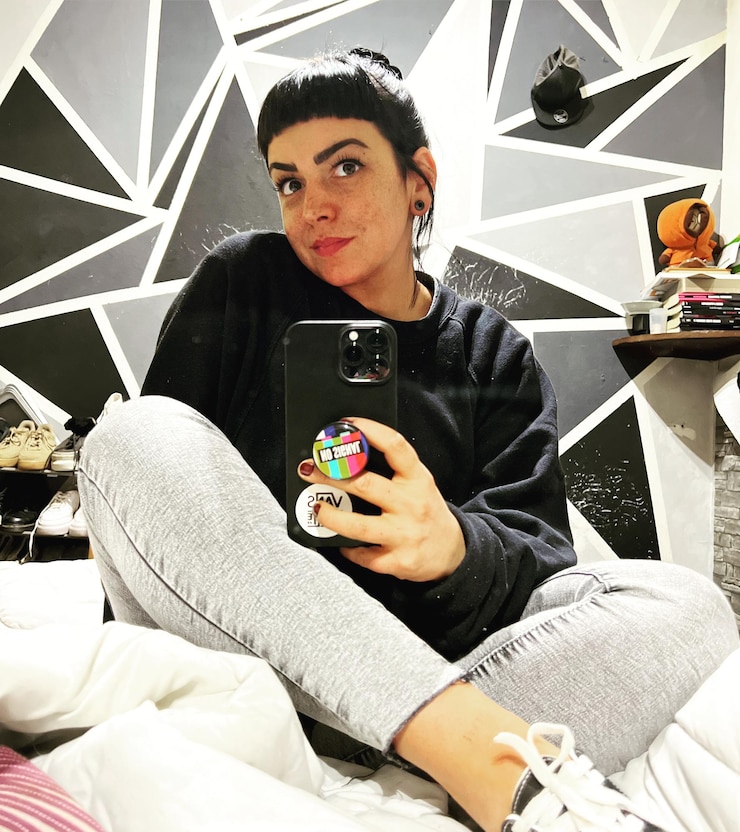 Foto mulher jovem a usar telemóvel.