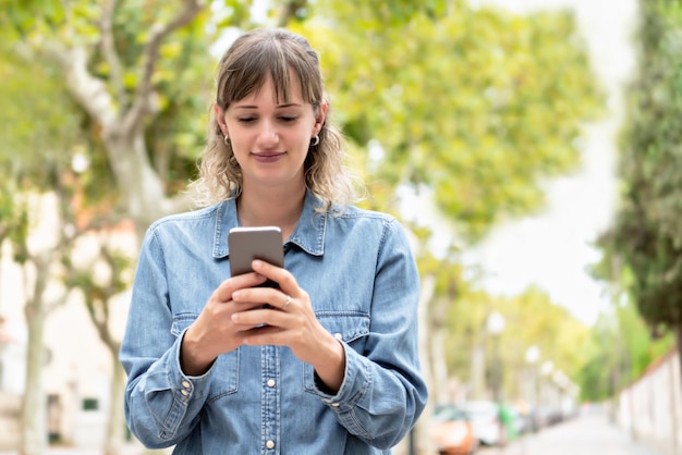 Mulher jovem a usar telemóvel.