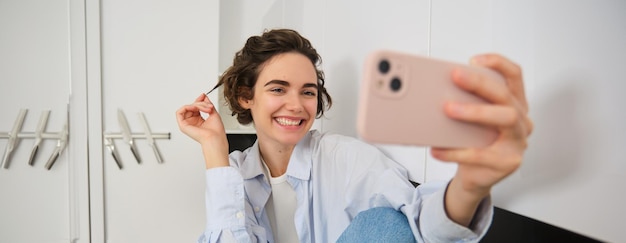 Foto mulher jovem a usar telemóvel.