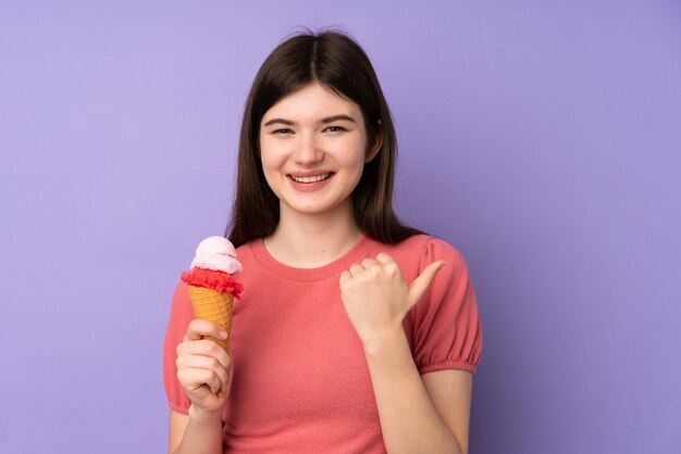 Mulher jovem adolescente ucraniano segurando um sorvete de corneta apontando para o lado para apresentar um produto