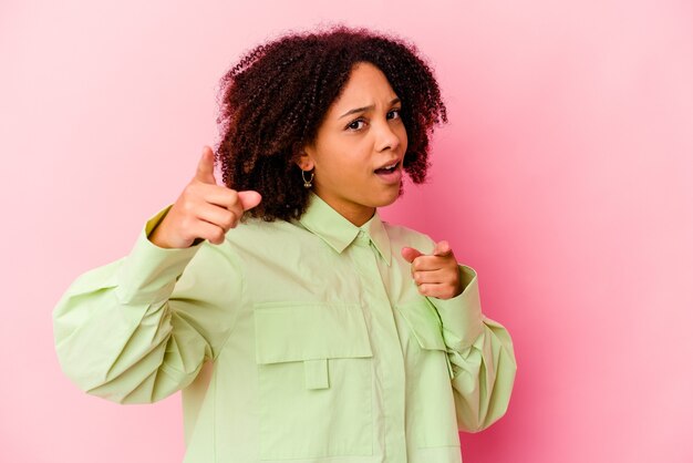 Mulher jovem afro-americana de raça mista isolada apontando para a frente com os dedos.