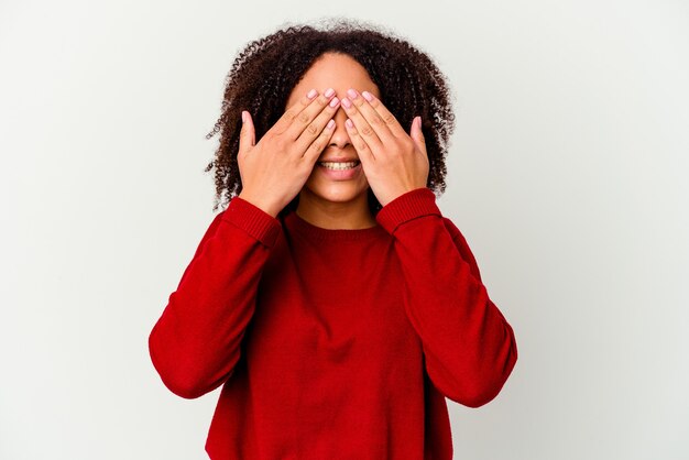 Mulher jovem afro-americana de raça mista isolada cobre os olhos com as mãos, amplamente esperando por uma surpresa.