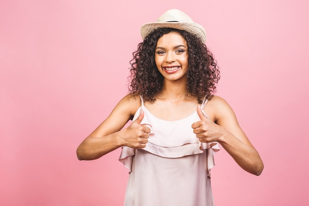 Mulher jovem afro-americana feliz isolada em um fundo rosa, fazendo um sinal de positivo com a mão.