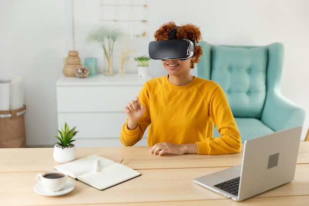 Mulher jovem afro-americana usando óculos de realidade virtual metaverse vr em casa menina