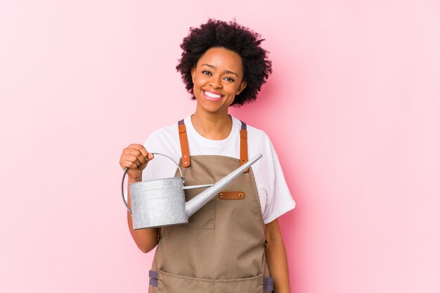 Mulher jovem afro-americano jardineiro feliz, sorridente e alegre.