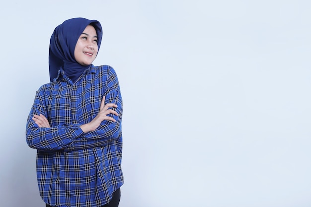 Mulher jovem alegre e sorridente tem expressão positiva tem olhar de alegria, estar em alto astral, usando hijab, isolado sobre a parede branca, expressão agradável