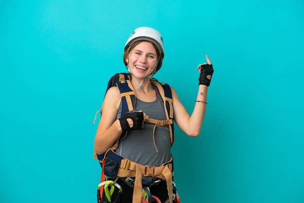 Mulher jovem alpinista inglesa isolada em fundo azul fazendo gesto de guitarra