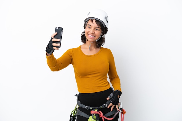 Mulher jovem alpinista isolada no fundo branco fazendo uma selfie
