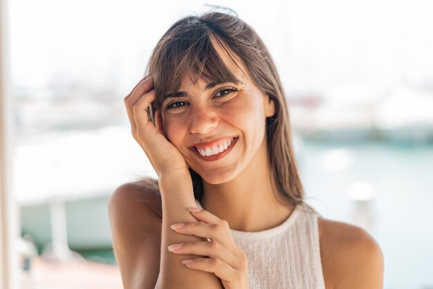 Mulher jovem ao ar livre com expressão feliz