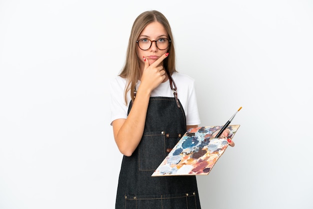 Mulher jovem artista lituana segurando uma paleta isolada no pensamento de fundo branco