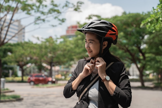 Mulher jovem asiática, desgastar, capacete, bicicleta segurança