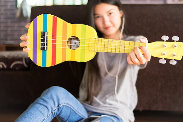 Foto mulher jovem asiática tocando cavaquinho