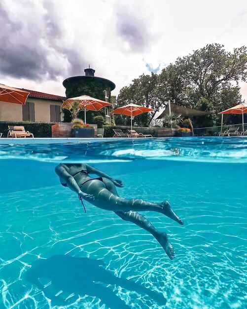 Mulher jovem atraente nada debaixo d'água Mulher nadando debaixo d'água na piscina