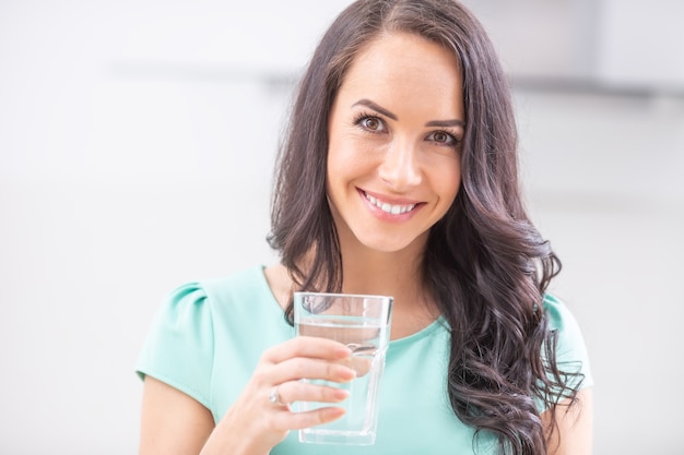 Mulher jovem bebe água limpa segue o regime de beber.