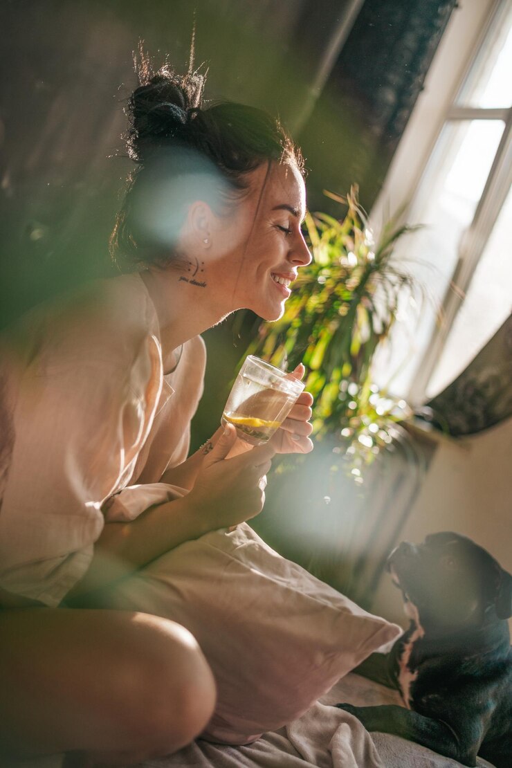Foto mulher jovem bebendo água de vidro enquanto está sentada ao ar livre