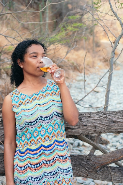 Mulher jovem bebendo vinho branco ao ar livre