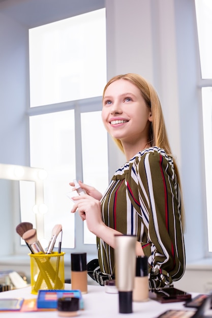 Mulher jovem bonita e positiva sorrindo enquanto aprecia sua beleza