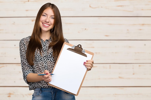 Mulher jovem bonita sorridente feliz com prancheta