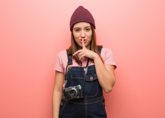 Mulher jovem bonito fotógrafo mantendo um segredo ou pedindo silêncio