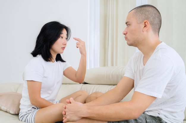 Mulher jovem brigando com o marido em casa