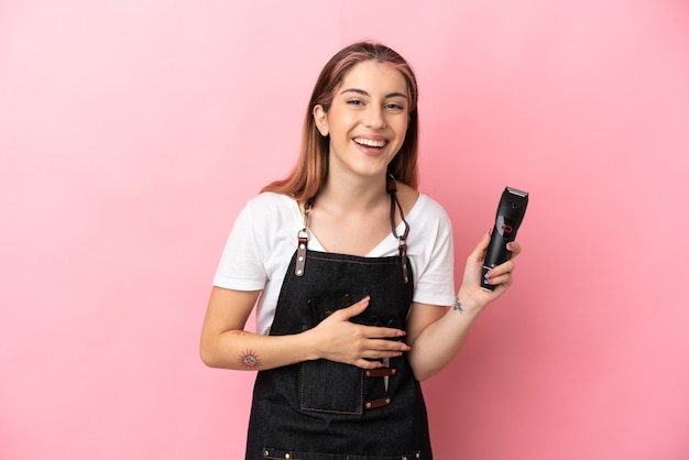 Mulher jovem cabeleireira isolada em rosa sorrindo muito