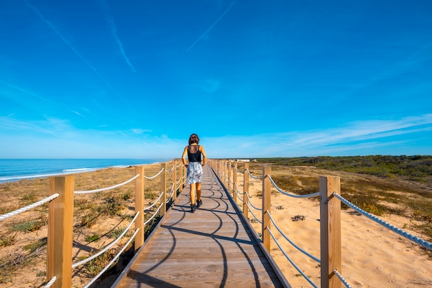 Mulher jovem caminhando ao longo do calçadão da praia Labenne Océan