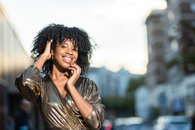 Mulher jovem caribenha com vestido dourado glamour para festa de ano novo