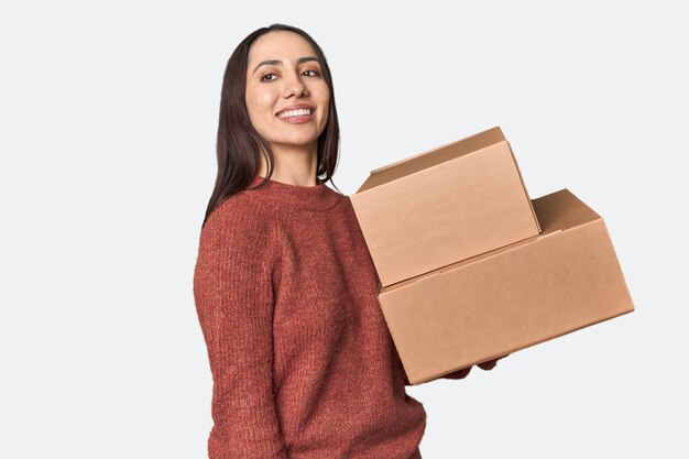 Foto mulher jovem caucasiana com caixas em movimento olha para um lado sorrindo alegre e agradável