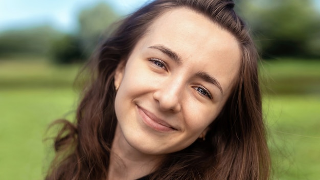 Mulher jovem caucasiana sorridente com olhos azuis e cabelo castanho