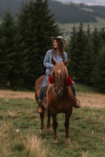 Mulher jovem cavalgando nas montanhas