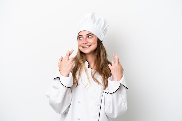 Mulher jovem chef caucasiana isolada em fundo branco com dedos cruzados