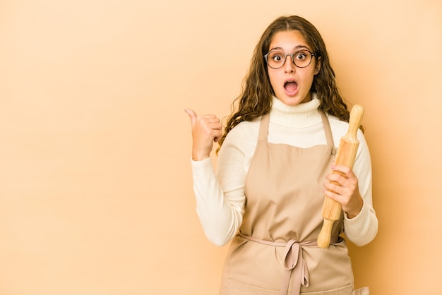 Mulher jovem chef isolada apontando para o lado