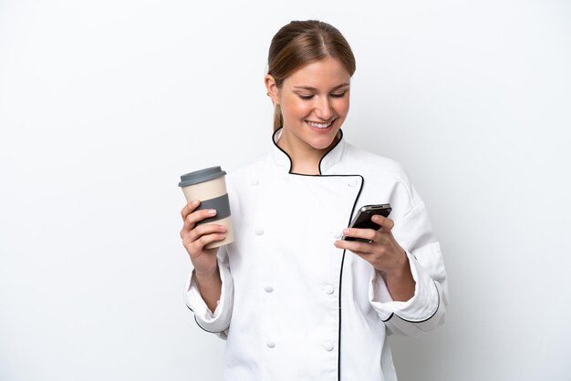Mulher jovem chef isolada no fundo branco segurando café para levar e um celular