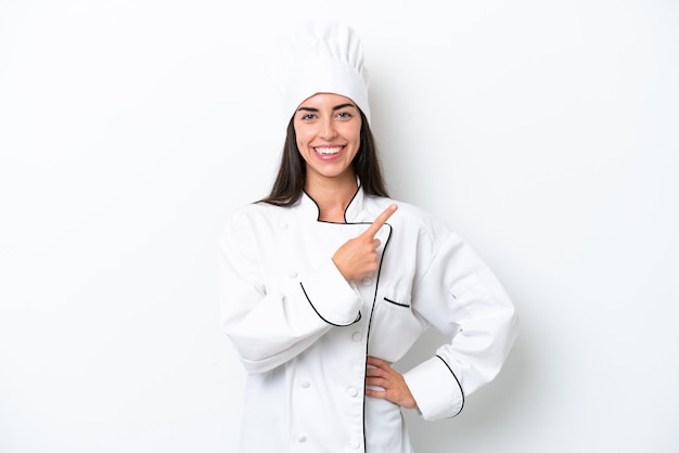 Mulher jovem chef sobre fundo branco, apontando para o lado para apresentar um produto