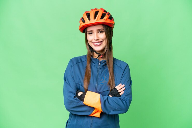 Foto mulher jovem ciclista sobre fundo croma chave isolado, mantendo os braços cruzados na posição frontal
