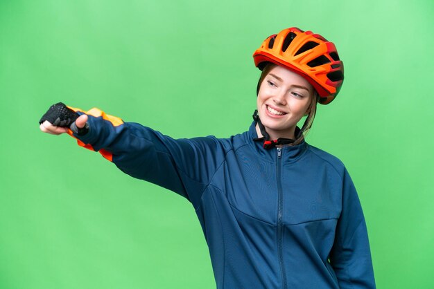 Mulher jovem ciclista sobre fundo croma isolado dando um polegar para cima gesto