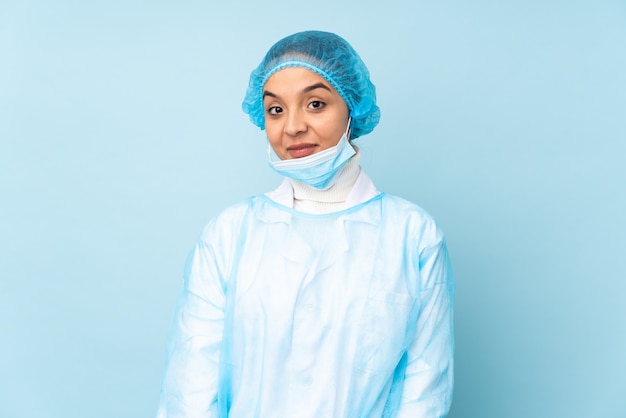 Mulher jovem cirurgião na risada uniforme azul