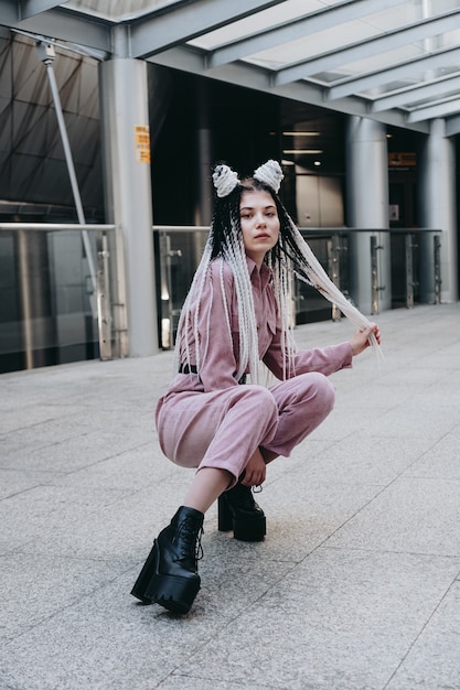 Mulher jovem com aparência futurista. garota com dreadlocks ou tranças pretas e brancas no contexto de um edifício futurista