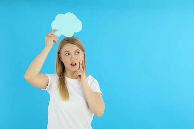 Mulher jovem com balão no fundo azul