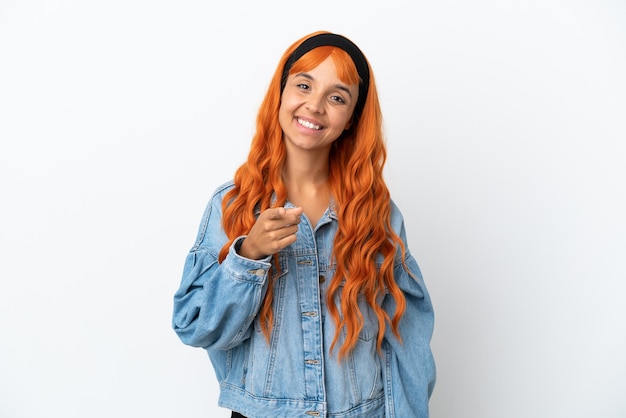 Foto mulher jovem com cabelo laranja isolado no fundo branco apontando para a frente com uma expressão feliz