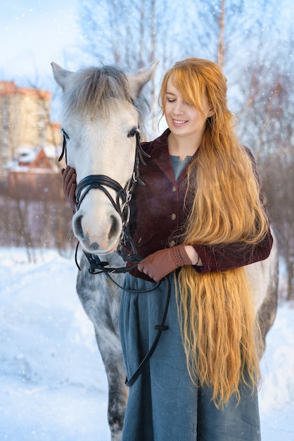 Mulher jovem, com, cabelo longo, com, cavalo, em, inverno